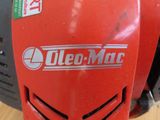 a close up of a red lawn mower on a wooden floor