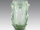 un vase en verre vert posé sur une table
