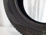 a close up of a tire on a white surface with a white curtain in the background