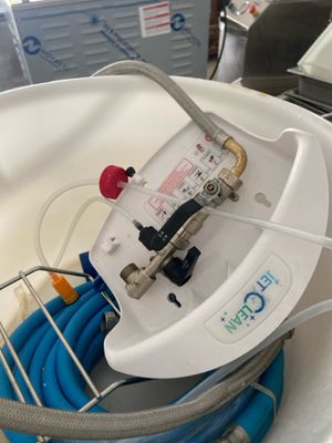 a white bucket with a blue hose and a water hose