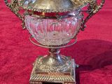 an antique silver plate and glass bowl on a red cloth