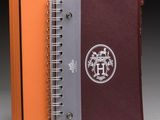 an orange and grey notebook with a logo on the cover