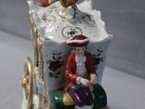 a figurine of a man riding on a horse drawn carriage