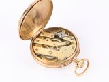 a gold pocket watch with a gold case on a white background