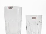 two clear glasses sitting next to each other on a white surface