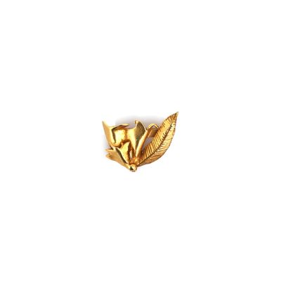 a close up of a gold flower brooch on a white background