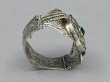 an image of a silver bracelet with a green stone in the center