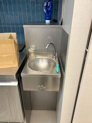 un évier en acier inoxydable dans le coin d'une salle de bains