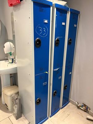 a blue locker in a bathroom with a sink and a toilet