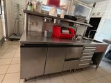 a kitchen with a stainless steel counter and a refrigerator