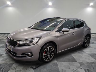 a grey car is parked on a checkered floor in a garage