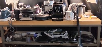 une table en bois sur laquelle sont posés tout un tas d'appareils électroménagers