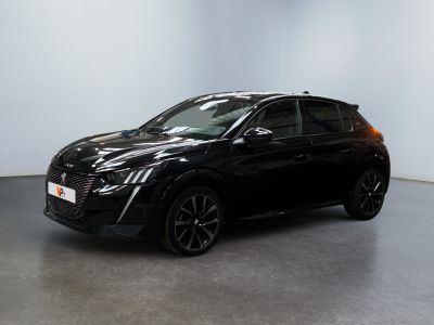 Une voiture noire est garée dans une pièce blanche au sol noir.