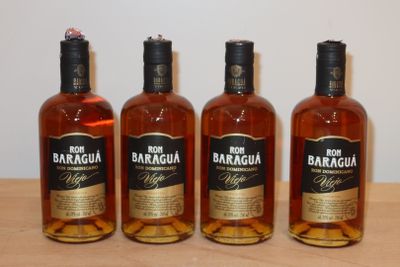 trois bouteilles d'alcool sont alignées sur une table en bois