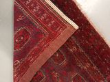 a red rug on the floor next to a pair of scissors