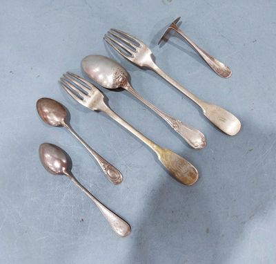 five silver spoons and two silver spoons on a table
