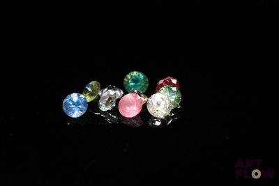 three different colored stones are arranged in a row on a black surface