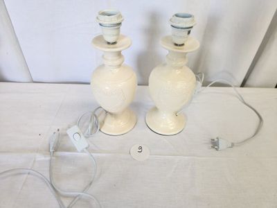 two white vases sitting on a table with wires attached to them