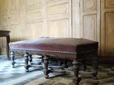 un banc au milieu d'une pièce au sol carrelé en damier