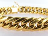 a close up of a gold bracelet on a white surface