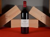 a bottle of wine sitting on a table next to wooden boxes