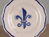 a blue and white plate with a fleur de lis design on it