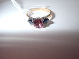 a ring with a pink and blue stone inside of it