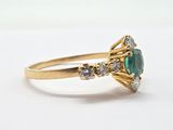 an image of a gold ring with a green and white stone