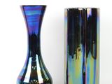 two vases sitting next to each other on a white surface