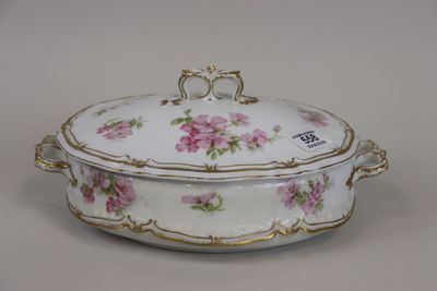 un bol blanc orné de fleurs roses, posé sur une table