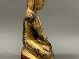 statue of a seated buddha on a wooden base