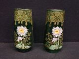 two vases with flowers painted on them sitting on a table