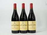 trois bouteilles de vin rouge posées côte à côte sur une table