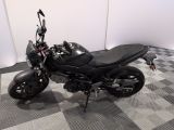 a black motorcycle that is parked on a checkered floor