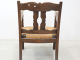 a wooden chair with a brown seat on a white floor