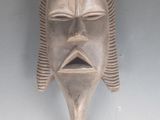 un gros plan d'un masque accroché au mur