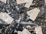many pieces of clothing wrapped in plastic bags on a table
