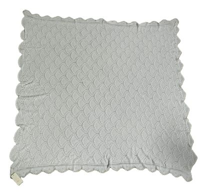 the white blanket has a lacy design on it
