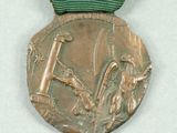 a bronze medal with a green ribbon around it