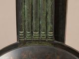 a large bronze vase with a column on top of it