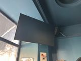 un téléviseur à écran plat suspendu au plafond dans une pièce