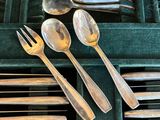 de nombreuses cuillères et fourchettes dans une boîte verte