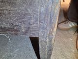 a close up of a wooden table with a drawer underneath it