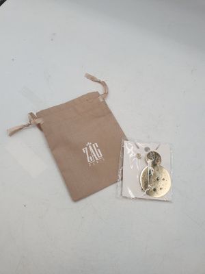 a small bag with a button on it next to a bag of buttons