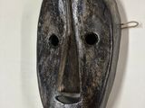 une image d'un masque en bois accroché au mur