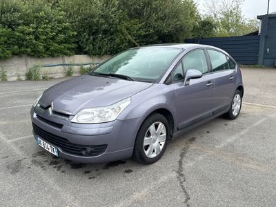 une Citroën grise garée sur un parking devant un immeuble