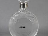 a close up of a bottle of perfume on a gray surface