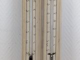 two old fashioned thermometers on display against a white wall