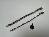 a silver chain with a black button attached to it