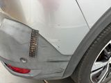 the rear bumper of a silver car with a sticker on it